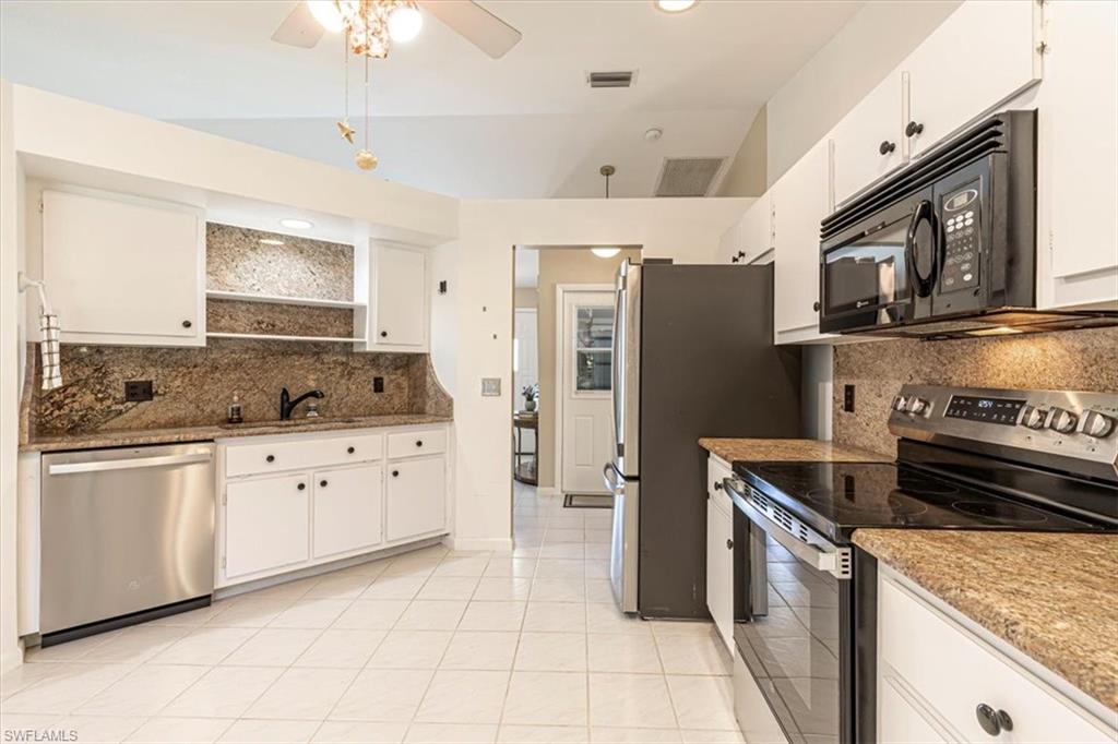 124 Versailles Circle Naples, FL 34112 - Photo 10 of 21 a kitchen with stainless steel appliances granite countertop a stove top oven a refrigerator a sink and dishwasher