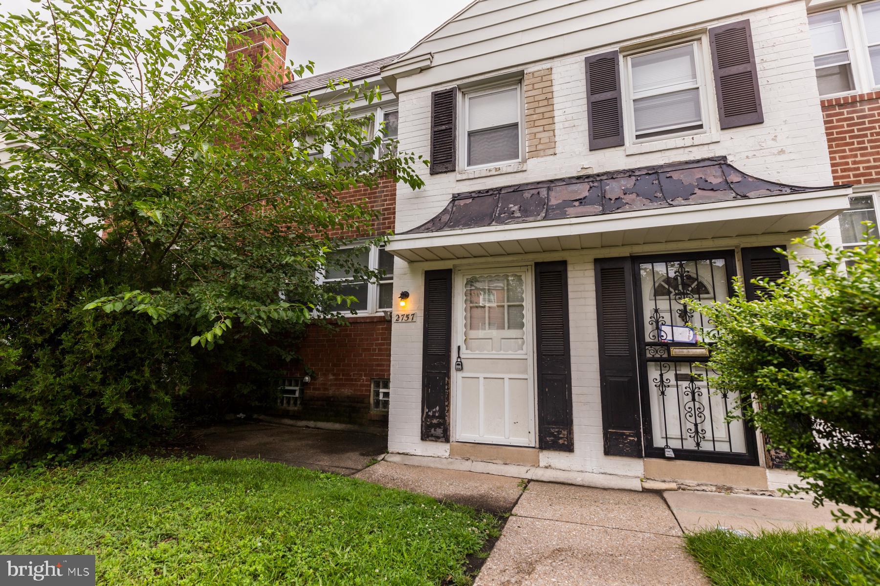 a red brick house with trees in front of it