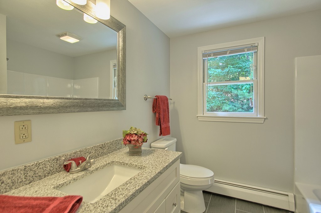 13 Valley Road Groton, MA 01450 - Photo 16 of 30 a bathroom with a granite countertop sink a toilet and a mirror