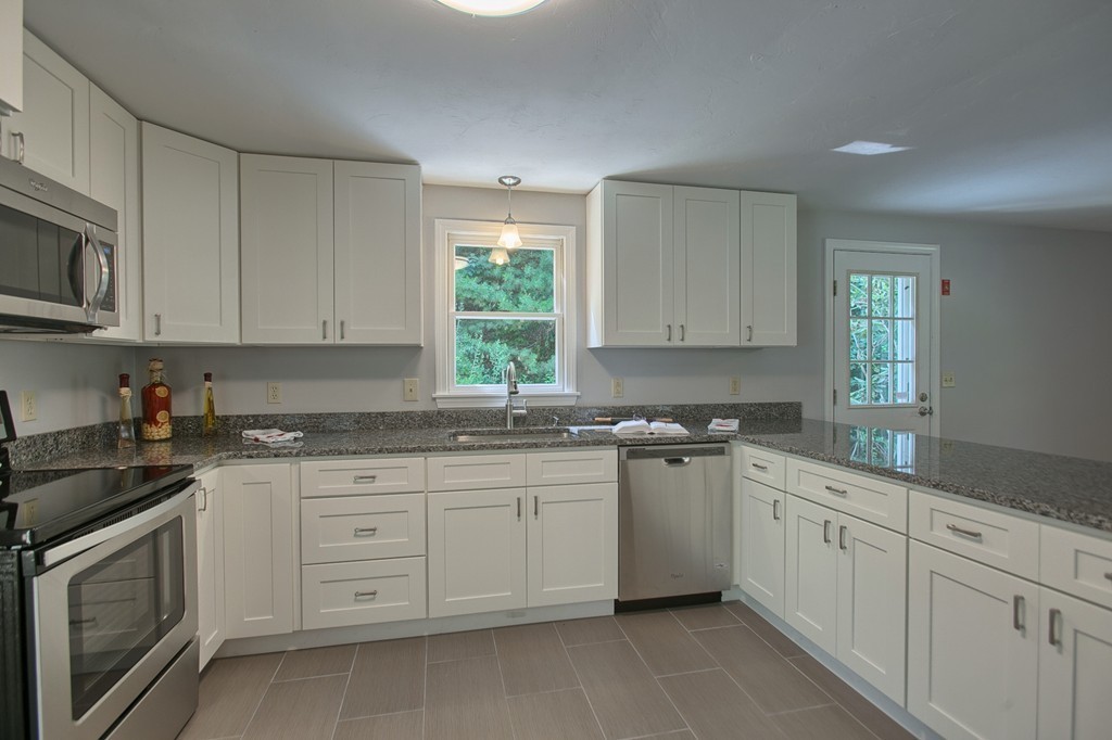 13 Valley Road Groton, MA 01450 - Photo 5 of 30 a kitchen with white cabinets appliances a sink and a window