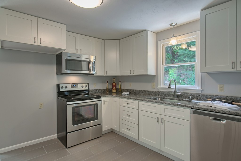 13 Valley Road Groton, MA 01450 - Photo 6 of 30 a kitchen with granite countertop white cabinets appliances a sink and a window