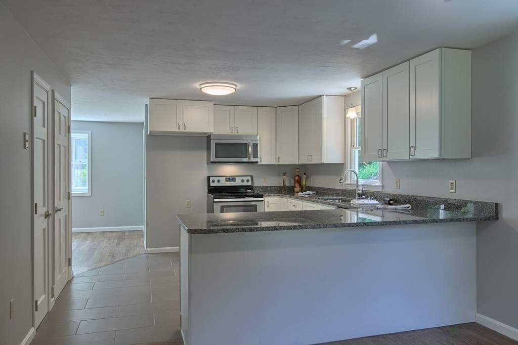 13 Valley Road Groton, MA 01450 - Photo 9 of 30 a kitchen with stainless steel appliances granite countertop a sink stove and refrigerator