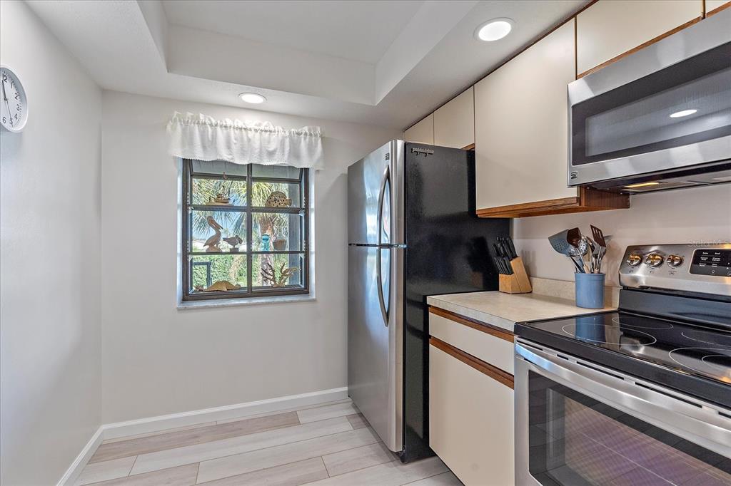 320 Mission Trail North, Unit B Venice, FL 34285 - Photo 11 of 25 a kitchen with stainless steel appliances a refrigerator and a stove