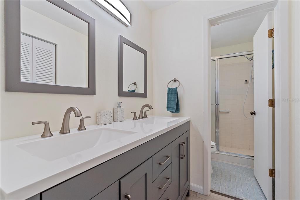 320 Mission Trail North, Unit B Venice, FL 34285 - Photo 15 of 25 a bathroom with a double vanity sink and a mirror