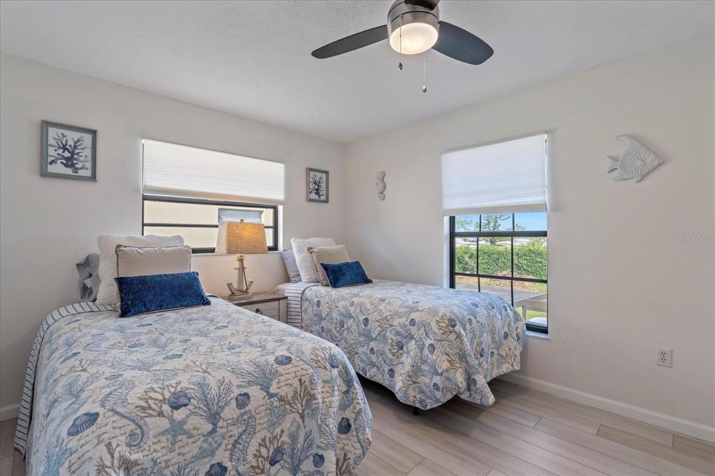 320 Mission Trail North, Unit B Venice, FL 34285 - Photo 17 of 25 a bedroom with two large bed and a window