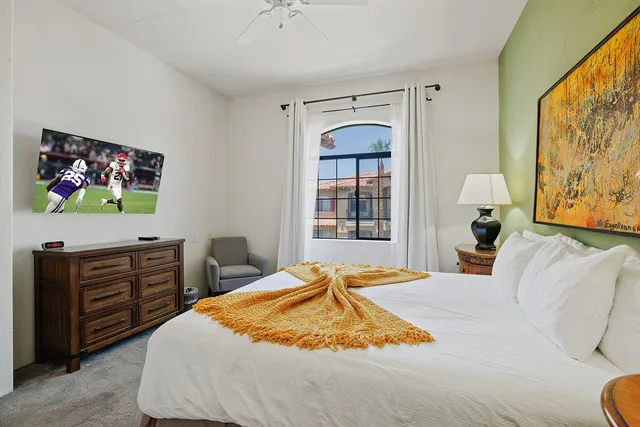 a bedroom with a bed and dresser with mirror