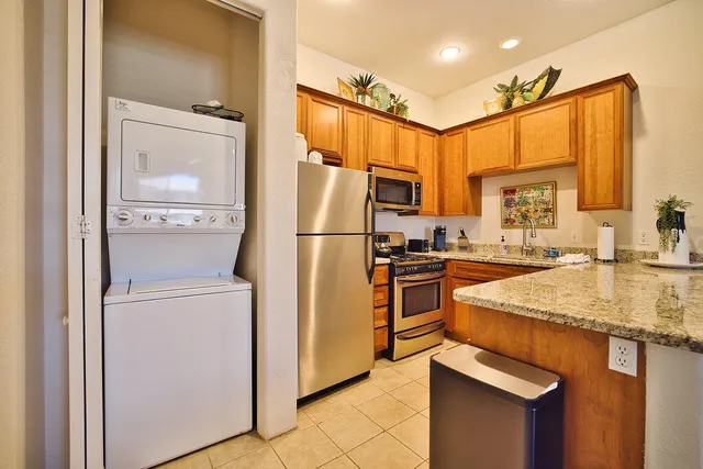 a kitchen with stainless steel appliances granite countertop a refrigerator and a sink