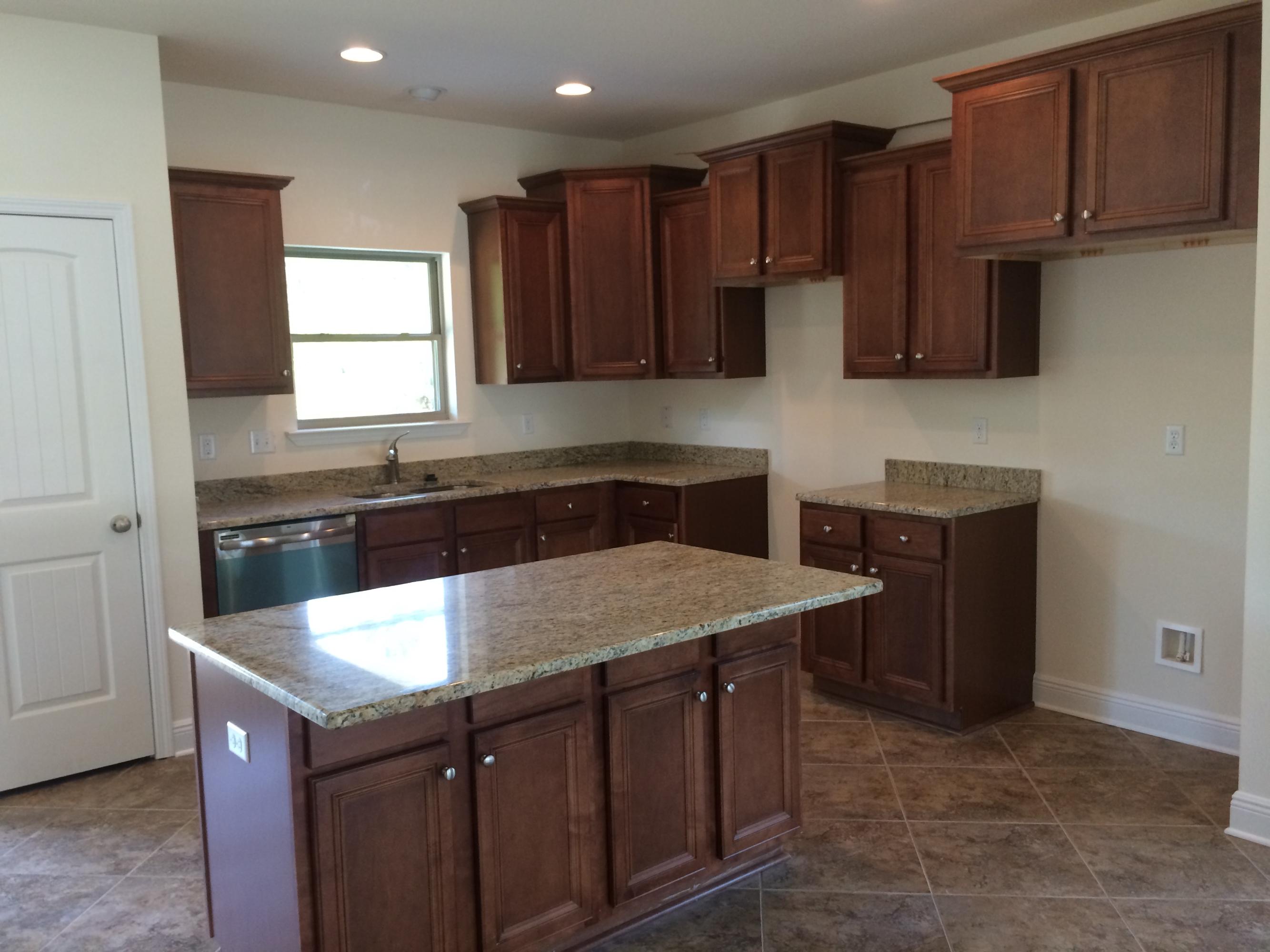 124 Pin Oak Loop Santa Rosa Beach, FL 32459 - Photo 5 of 19 a kitchen with a sink dishwasher a stove and a refrigerator with wooden cabinets