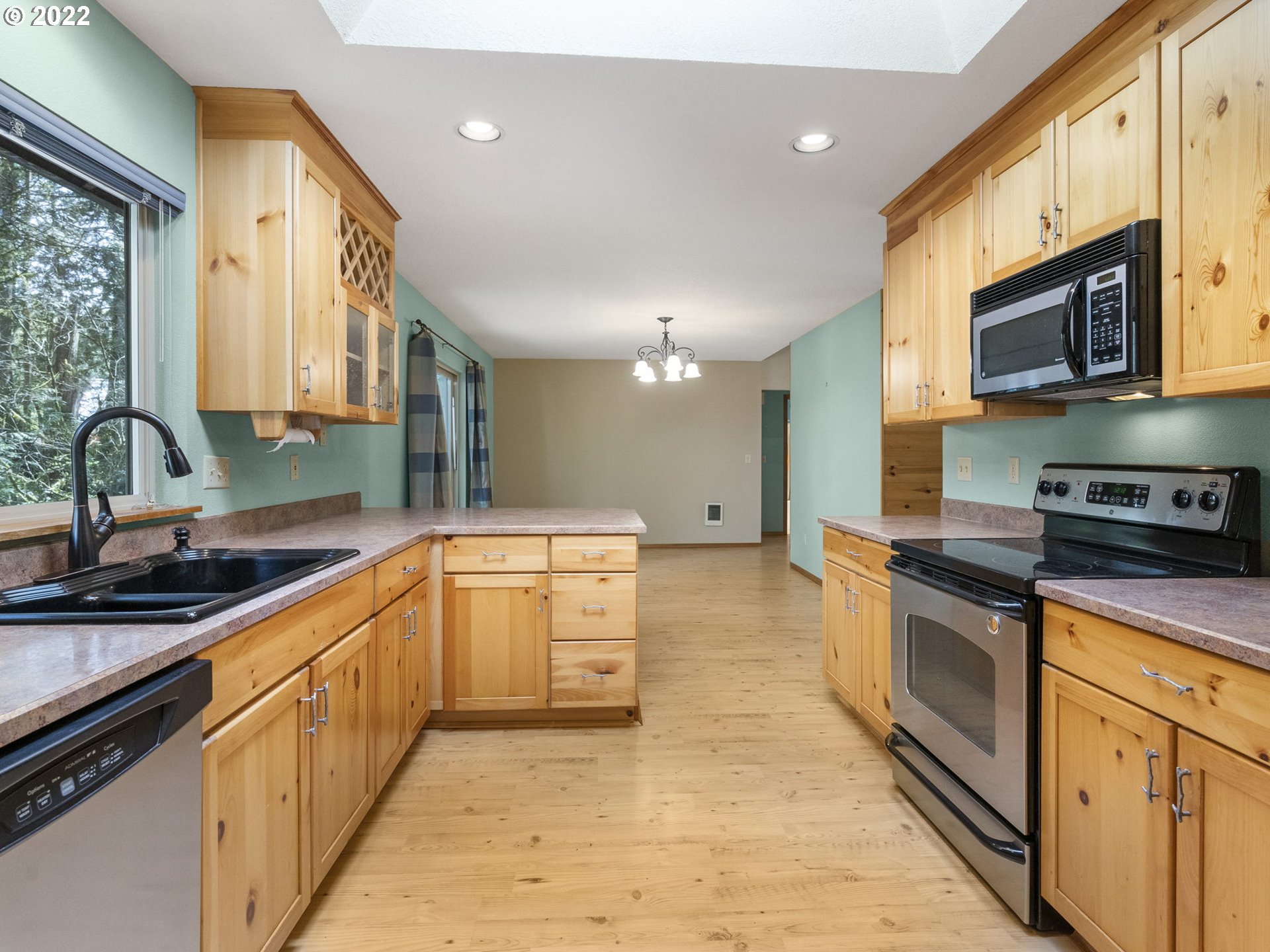 21676 East Lodge Lane Rhododendron, OR 97049 - Photo 8 of 32 a large kitchen with stainless steel appliances granite countertop a stove a sink and a microwave