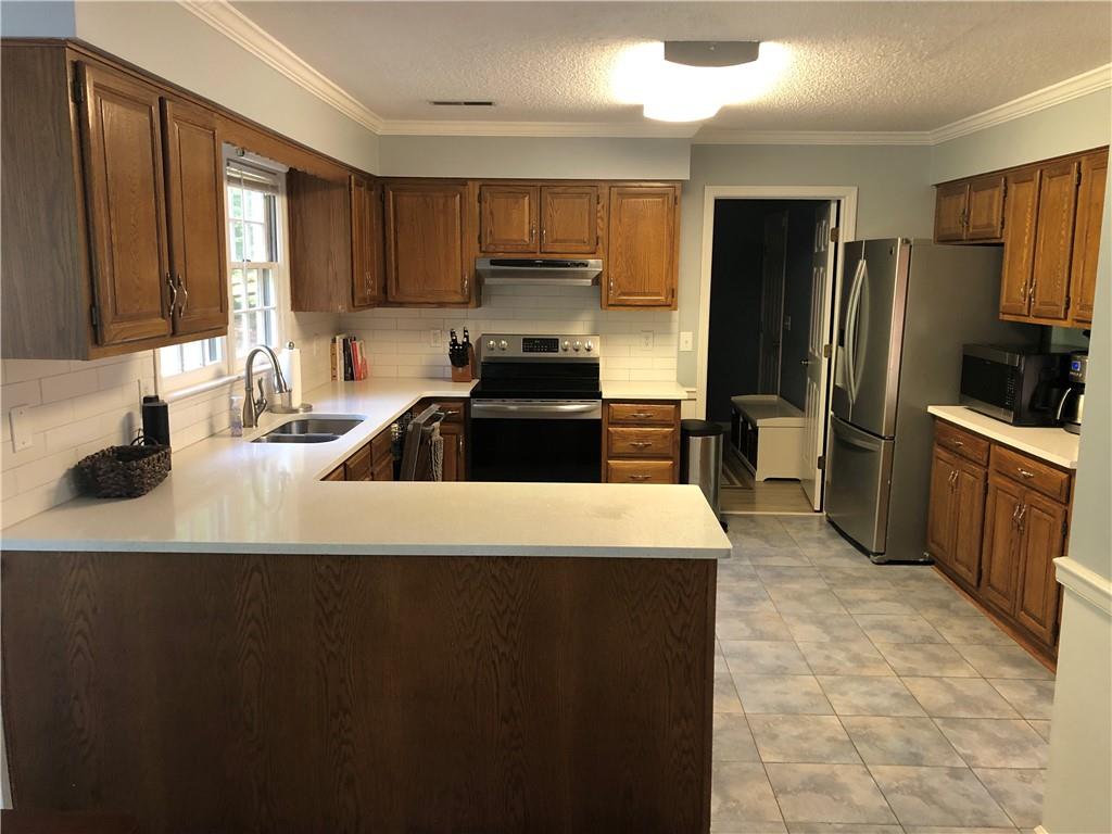 490 Sherman Oaks Way Alpharetta, GA 30004 - Photo 3 of 21 a kitchen with kitchen island a sink stove and refrigerator