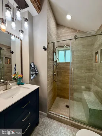 a bathroom with a shower sink vanity and mirror
