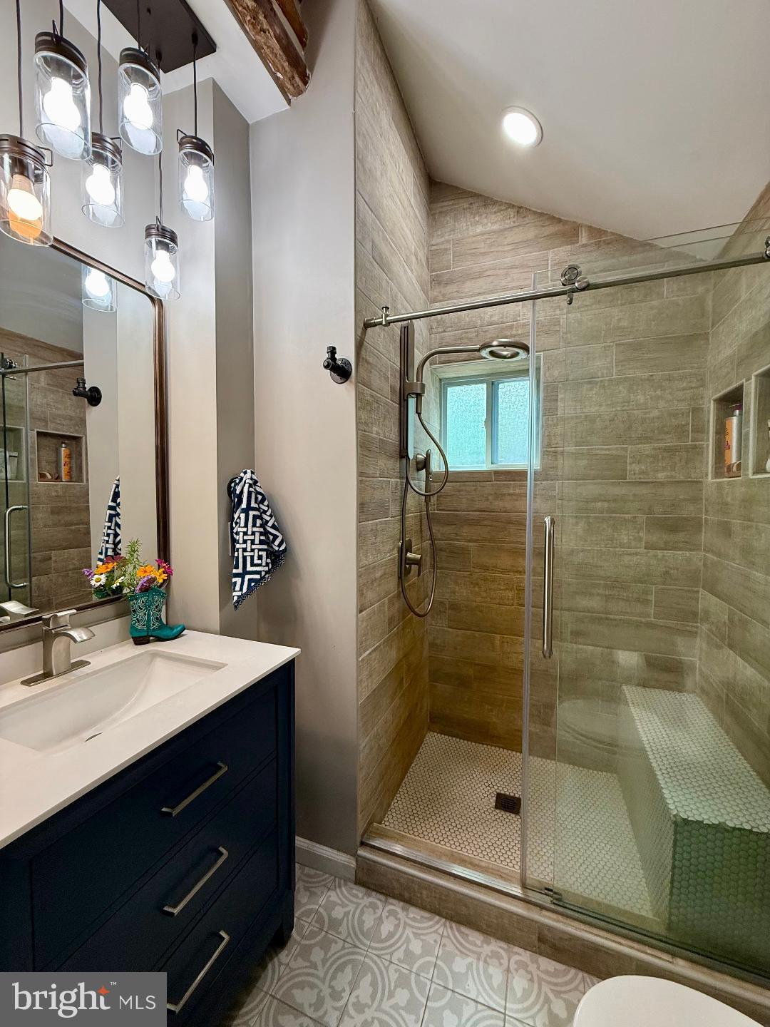 8389 Highview Street Manassas, VA 20112 - Photo 11 of 26 a bathroom with a shower sink vanity and mirror