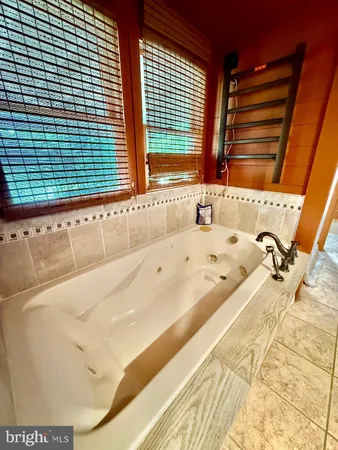 a bathroom with a tub sink and a mirror