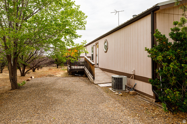 740 Riddle Drive Fredonia, AZ 86022 - Photo 2 of 20 Exterior side profile with a gravel ground cover, established trees, and a raised wooden deck leading to an entry door