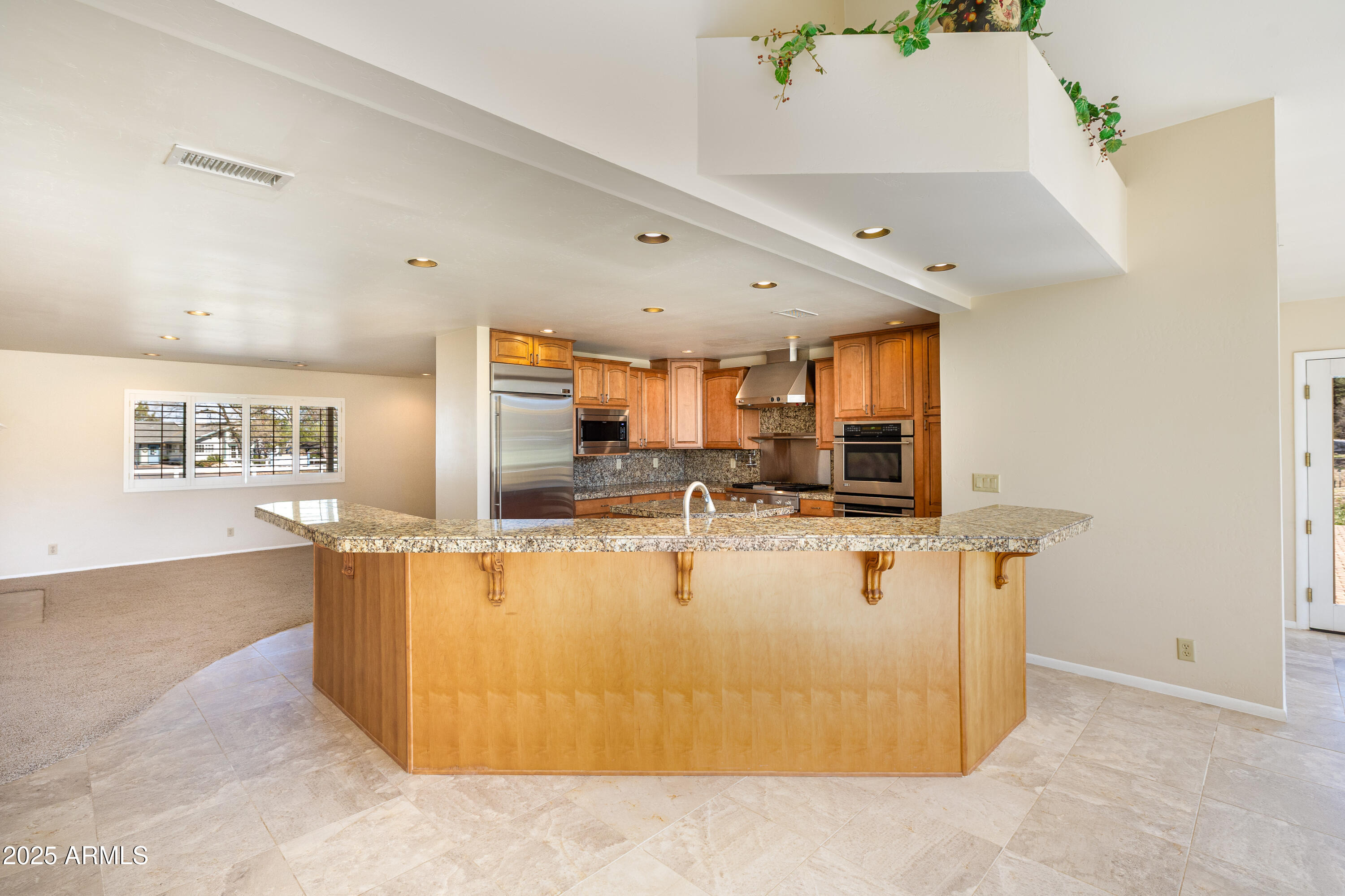 8230 Koch Field Road Flagstaff, AZ 86004 - Photo 14 of 69 a view of a kitchen with kitchen island a counter top space a sink a refrigerator and a window