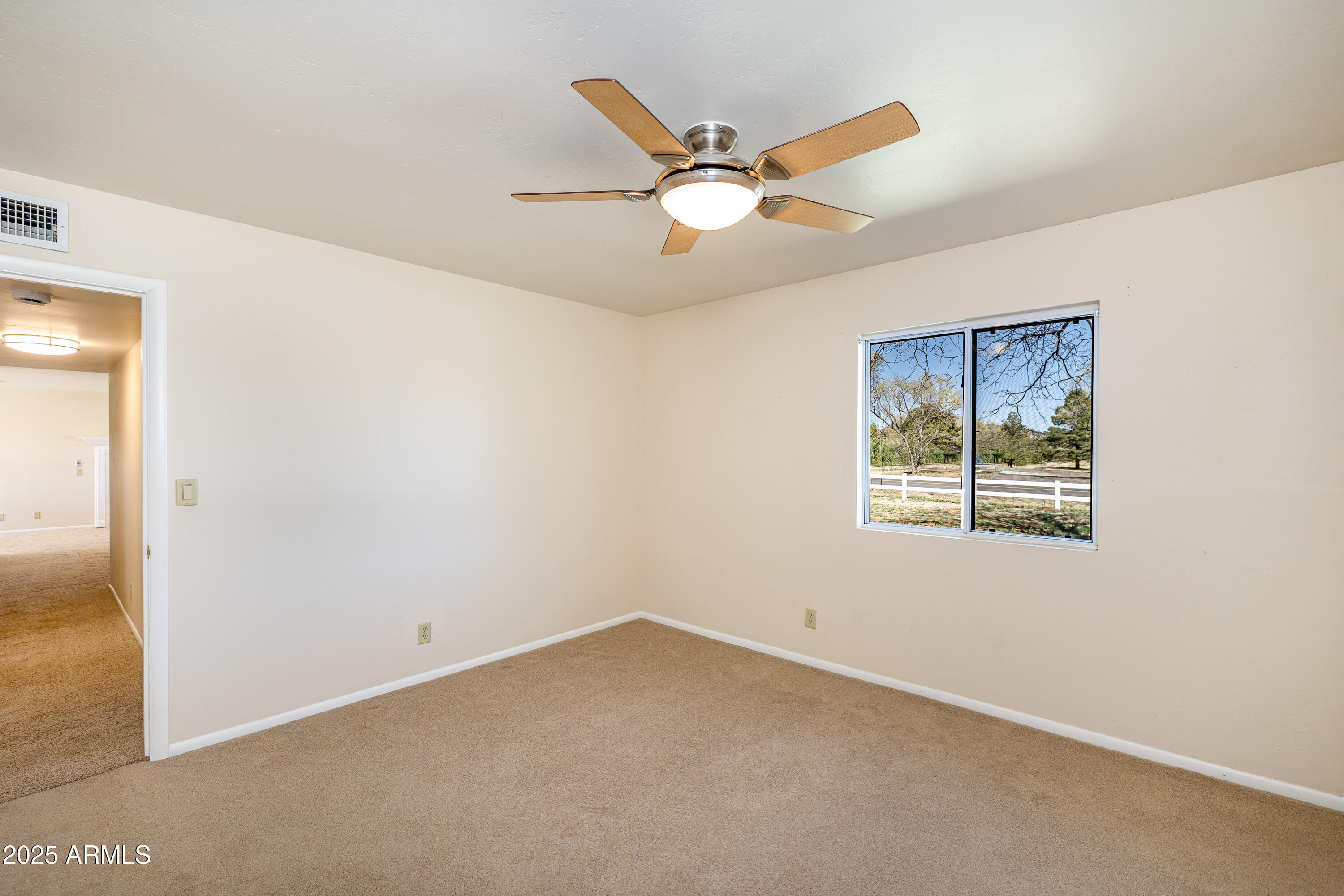 8230 Koch Field Road Flagstaff, AZ 86004 - Photo 28 of 69 an empty room with a window and a ceiling fan