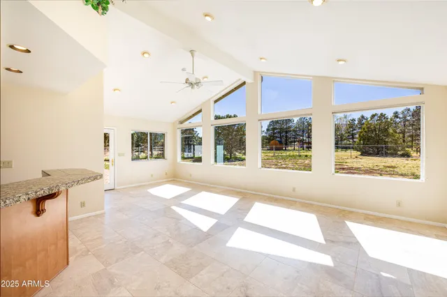 a view of a kitchen with kitchen island a counter top space a sink a refrigerator and a window