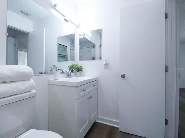 a bathroom with a sink vanity granite and toilet
