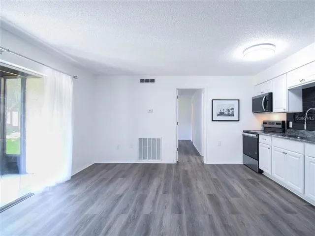 a view of a kitchen with wooden floor and a sink