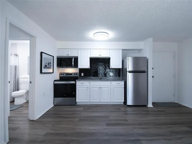 a kitchen with a refrigerator and a stove top oven