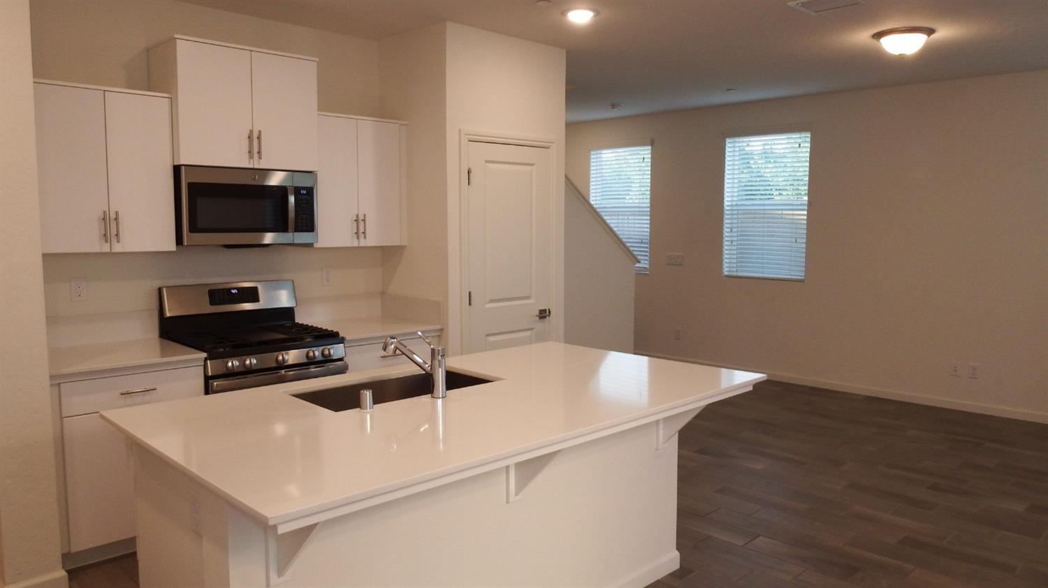 2008 North Walling Lane Clovis, CA 93619 - Photo 3 of 12 a kitchen with granite countertop a sink dishwasher a stove and a microwave with wooden floor