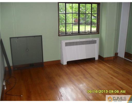130 West Hill Road Colonia, NJ 07067 - Photo 6 of 7 an empty room with wooden floor and windows