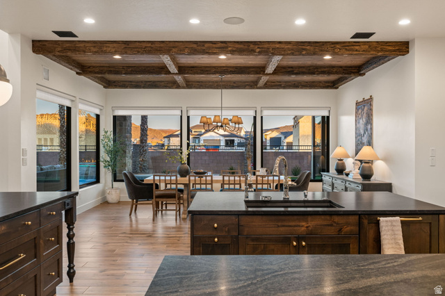 4871 South Homestead Way Washington, UT 84780 - Photo 25 of 151 Kitchen featuring dark wood finish cabinets, a chandelier, light wood-style flooring, dark stone counters, and beam ceiling