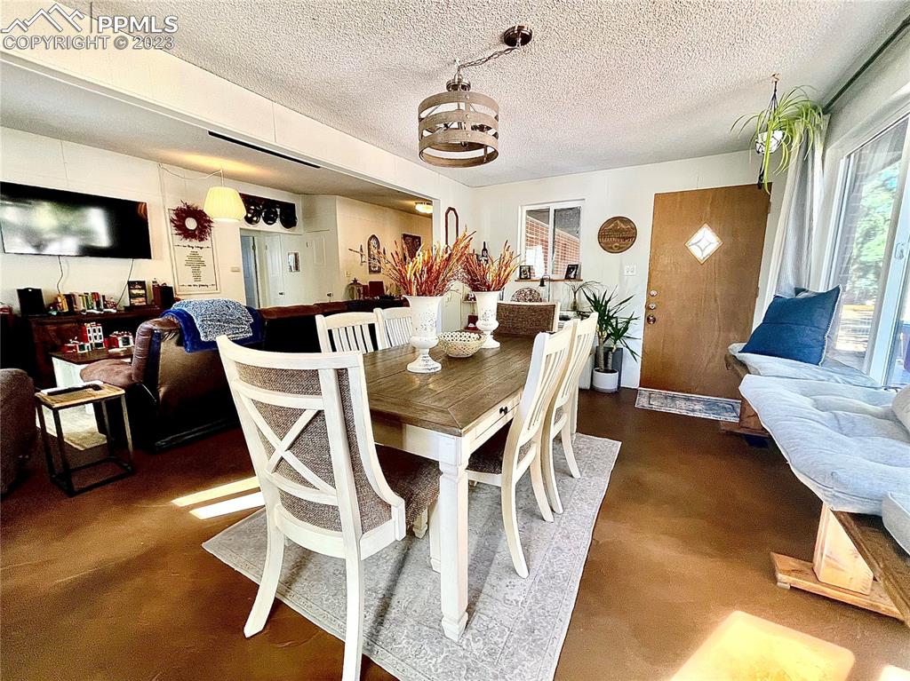 8715 Chipita Park Road Cascade, CO 80809 - Photo 11 of 25 a view of a dining room with furniture and a chandelier