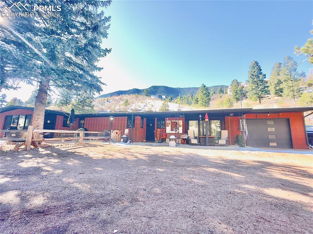 8715 Chipita Park Road Cascade, CO 80809 - Photo 24 of 25 a front view of a house with a yard and garage