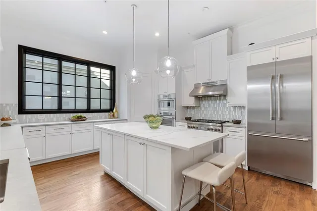 a kitchen with a sink stainless steel appliances and white cabinets