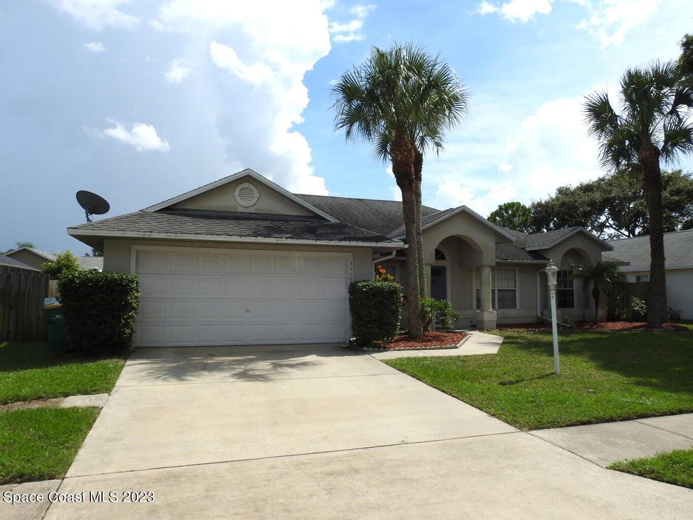 a front view of a house with a garden and trees