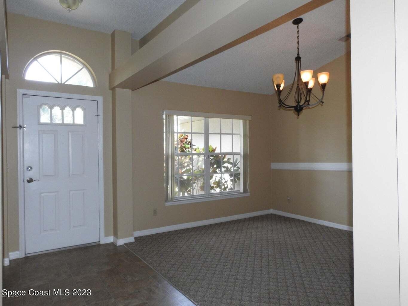 3368 Lakeview Circle Melbourne, FL 32934 - Photo 2 of 16 wooden floor in an empty room with a window