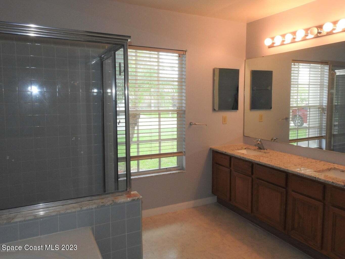 3368 Lakeview Circle Melbourne, FL 32934 - Photo 9 of 16 a bathroom with double vanity and a mirror