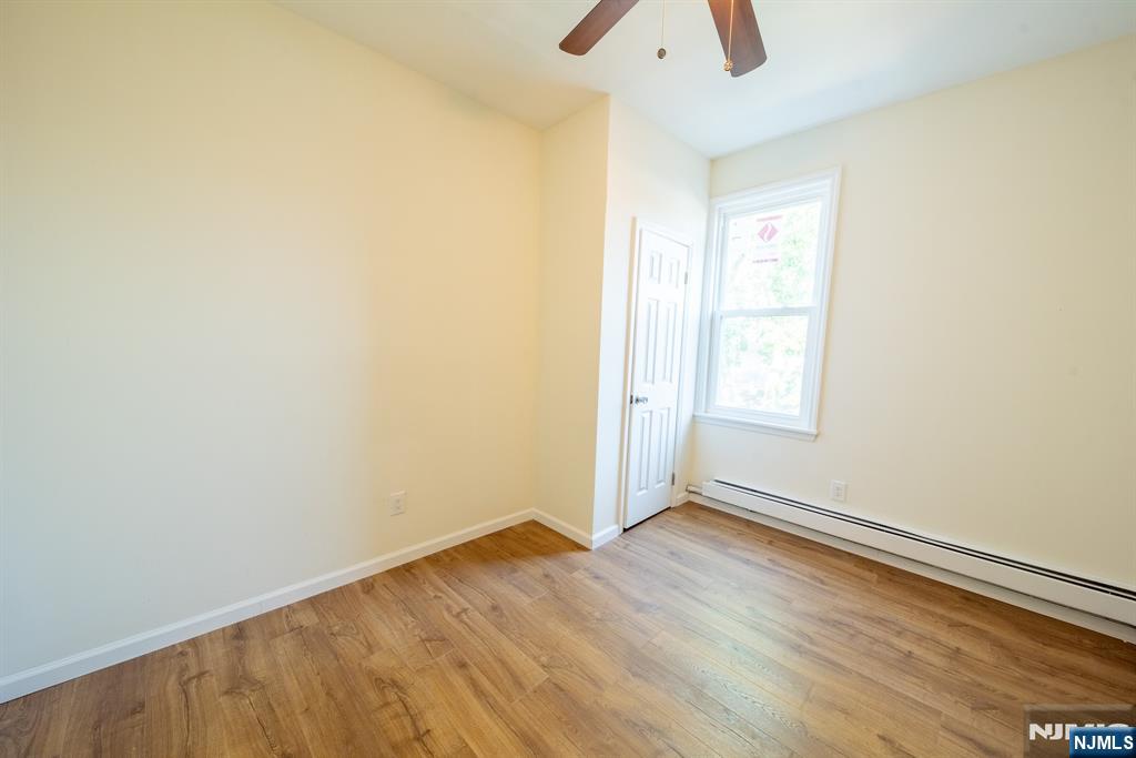 7723 Bergenline Avenue, Unit 3 North Bergen, NJ 07047 - Photo 11 of 12 an empty room with wooden floor and windows