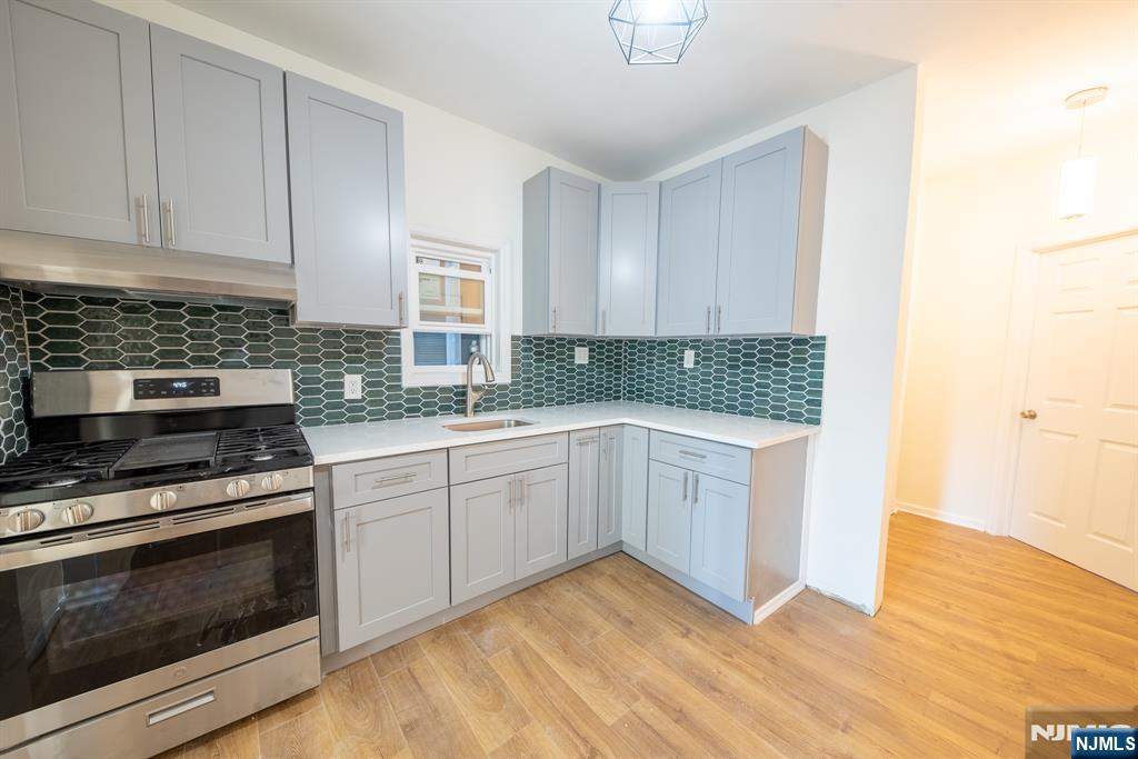 7723 Bergenline Avenue, Unit 3 North Bergen, NJ 07047 - Photo 3 of 12 a kitchen with cabinets appliances and wooden floor