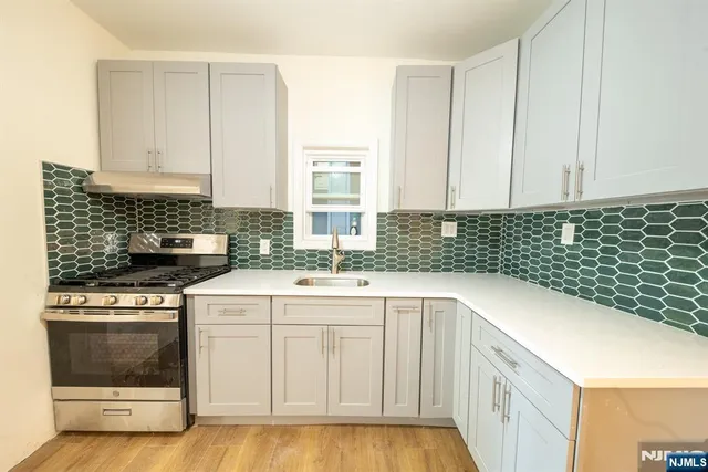 a kitchen with a sink stove and cabinets