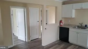 a kitchen with stainless steel appliances granite countertop white cabinets and wooden floor