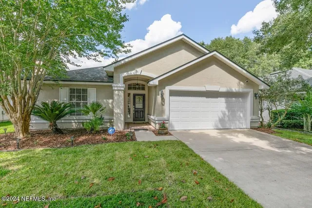 a front view of a house with a garden and plants