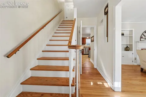 a view of a hallway with wooden floor and entryway