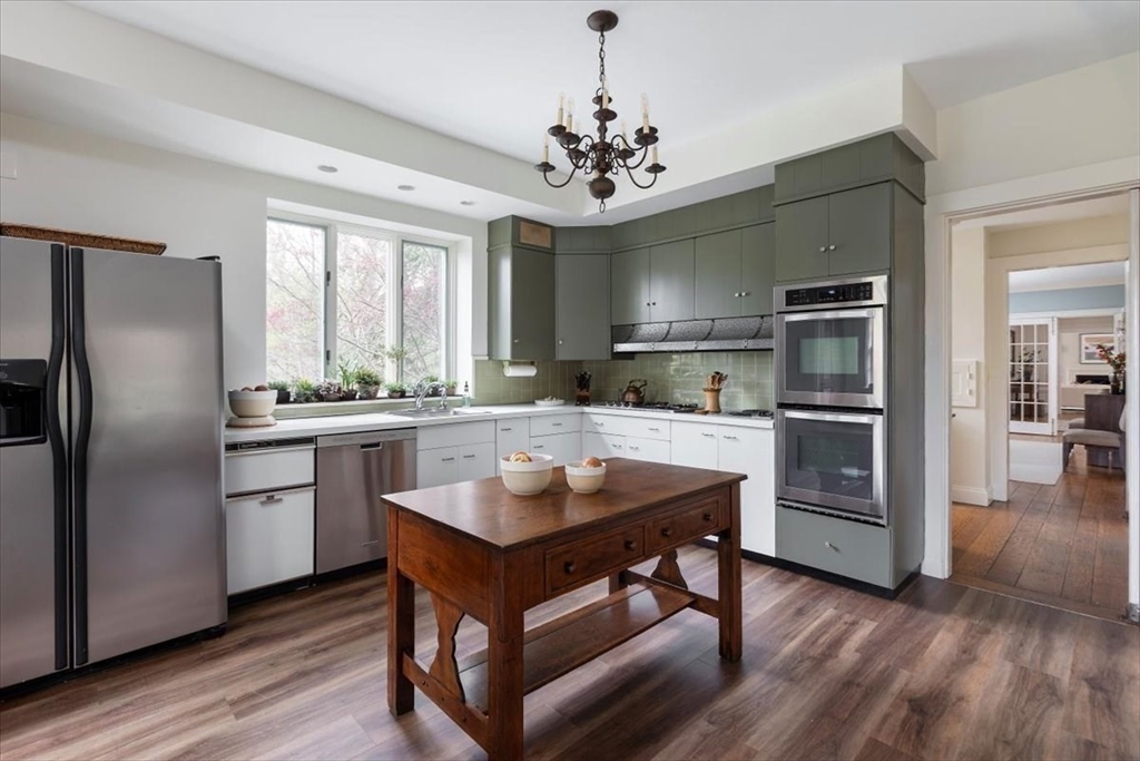 300 Warren Street Brookline, MA 02445 - Photo 16 of 35 a kitchen with stainless steel appliances granite countertop a refrigerator a stove and a sink with wooden floor