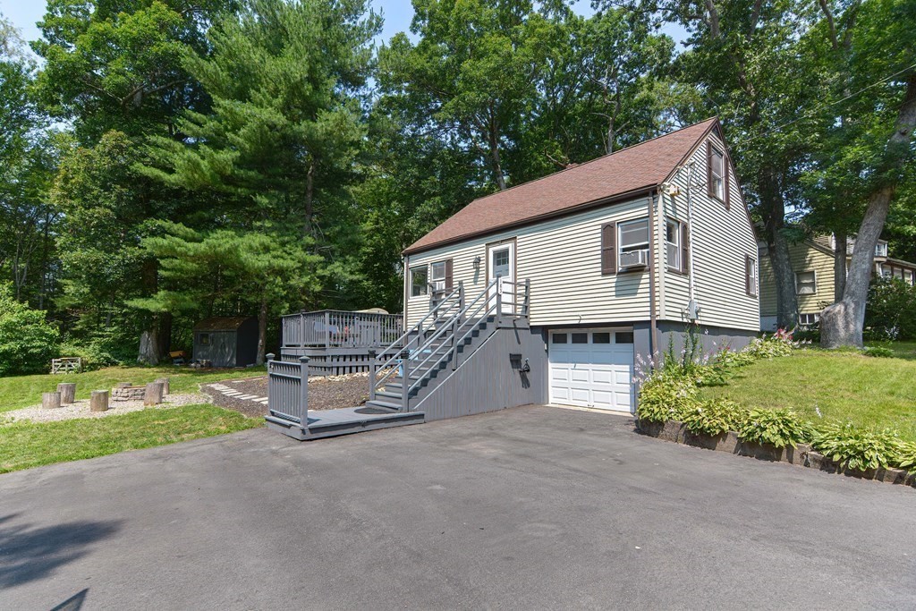 a view of a house with a yard and large tree