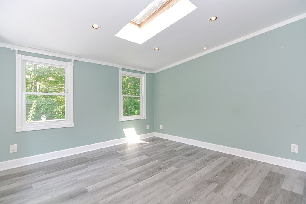 183 Brickel Road Stoughton, MA 02072 - Photo 13 of 38 a view of an empty room with wooden floor and a window