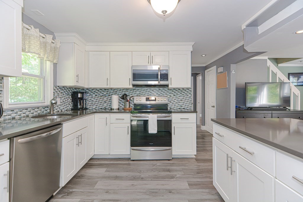 183 Brickel Road Stoughton, MA 02072 - Photo 2 of 38 a kitchen with granite countertop a stove top oven and sink