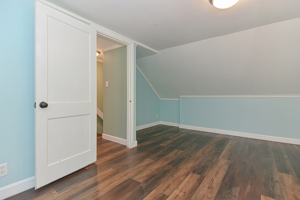183 Brickel Road Stoughton, MA 02072 - Photo 21 of 38 an empty room with wooden floor and a hallway