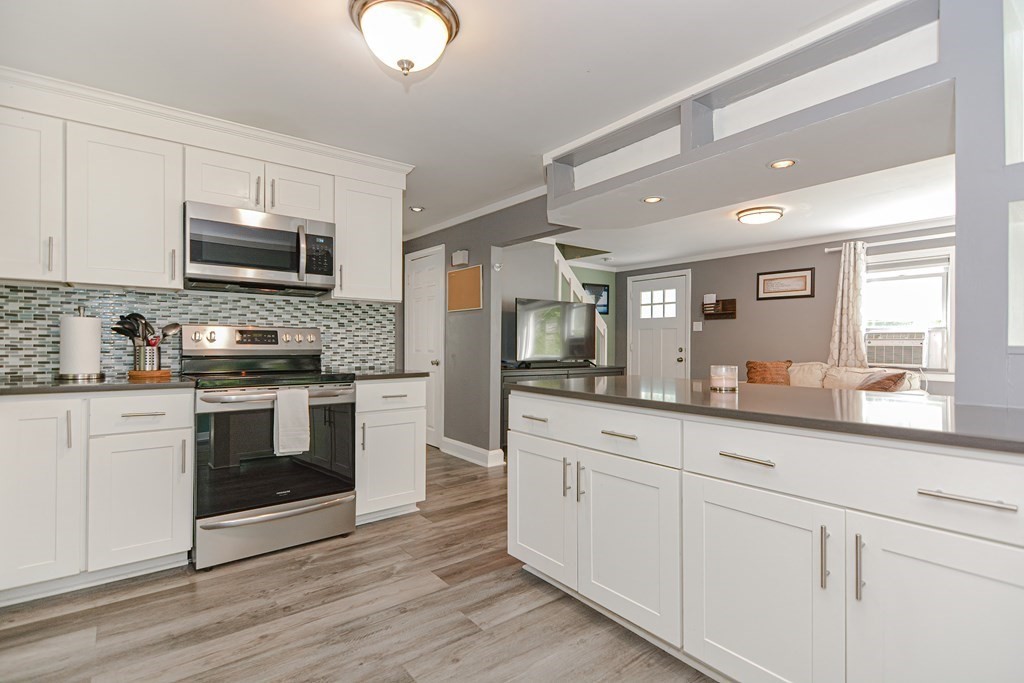 183 Brickel Road Stoughton, MA 02072 - Photo 4 of 38 a kitchen with granite countertop white cabinets and white appliances