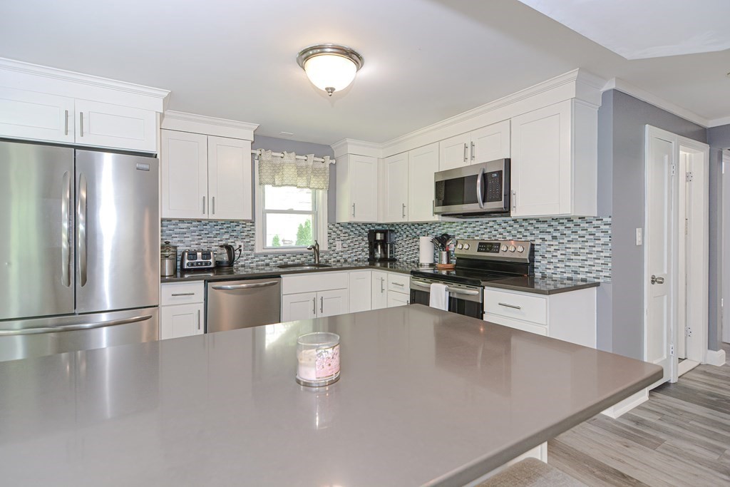 183 Brickel Road Stoughton, MA 02072 - Photo 5 of 38 a kitchen with granite countertop a refrigerator stove top oven and sink