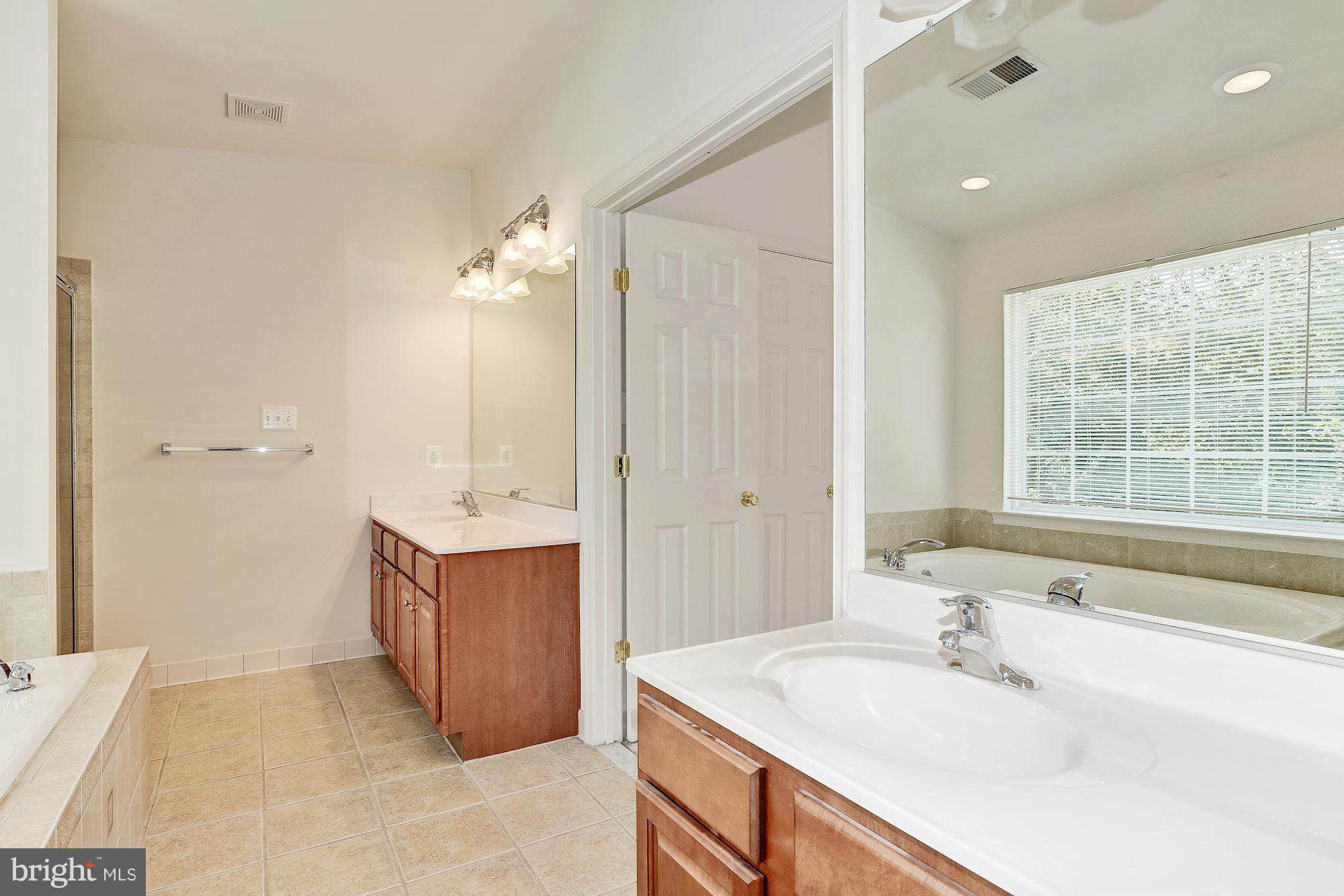 9700 Hickory Spring Lane Gaithersburg, MD 20882 - Photo 16 of 21 a bathroom with a tub sink and mirror