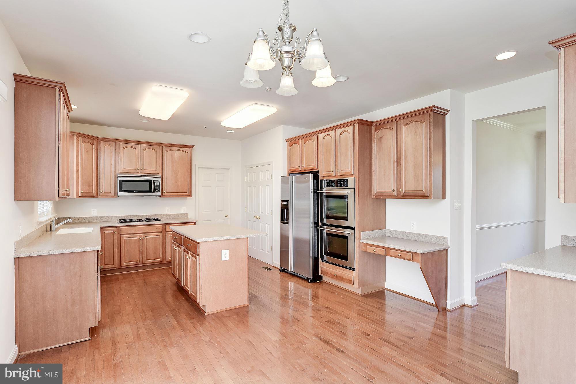 9700 Hickory Spring Lane Gaithersburg, MD 20882 - Photo 5 of 21 a open kitchen with a refrigerator and microwave