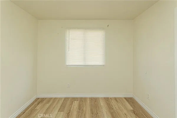 a view of a room with wooden floor and small window