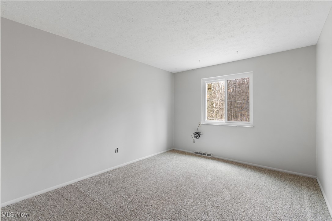 6462 State Road, Unit 4 Parma, OH 44134 - Photo 29 of 42 Carpeted empty room featuring baseboards, visible vents, and a textured ceiling
